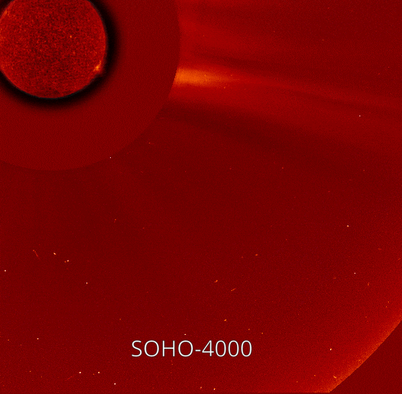 In this animated GIF, two small comets appear one after the other near the bottom  of a red-colored background speckled with white stars and move toward the Sun, which appears in red in the upper left. The first comet, which is brighter, is labeled SOHO-3999 and the second is labeled SOHO-4000.
